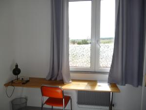 d'un bureau et d'une chaise en face d'une fenêtre. dans l'établissement Mousse appartement à Sangatte au premier étage à 50 metres de la plage, à Sangatte