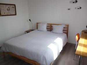 サンガットにあるMousse appartement à Sangatte au premier étage à 50 metres de la plageの白いシーツが敷かれた大きなベッドのある寝室
