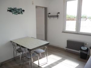 サンガットにあるMousse appartement à Sangatte au premier étage à 50 metres de la plageの窓のある部屋にあるテーブルと椅子