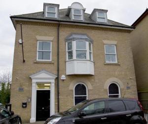 una casa con un coche aparcado delante de ella en Lovely 2-bedroom apartment in the heart of chelmsford, en Chelmsford
