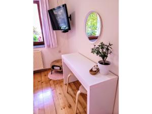 Habitación con escritorio blanco y TV. en Apartma Stanka, en Bistrica ob Sotli