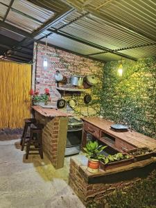 an outdoor kitchen with a table and a stone wall at Relajante, Mágico cautivador, tranquilidad y Paz - Piedechinche - Santa Elena - Hda El Paraíso. in Piedechinche