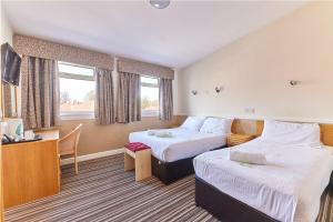 a hotel room with two beds and a desk at Properties Unique Dene Rooms - Family Room in Newcastle upon Tyne