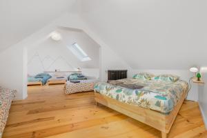 1 dormitorio con 2 camas y suelo de madera en la Zinguerie de la Plage - plage 300m, babyfoot, arcade, familial et design en Saint-Pair-sur-Mer