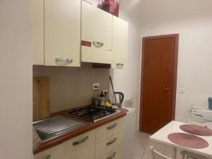 a kitchen with white cabinets and a stove top oven at Appartamentino in Pigneto storico in Rome