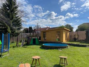 einen Hinterhof mit einem kleinen Haus und einem Spielplatz in der Unterkunft Apartmán u Rossniček Moravský kras in Kulířov