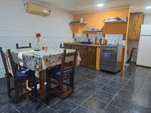 a kitchen with a table with chairs and a stove at Complejo Las Palmeras Casa 1 in San Clemente del Tuyú