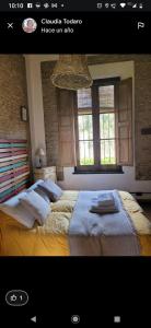 - une chambre avec 2 lits et 2 fenêtres dans l'établissement Hostería Casa de Campo, à Chascomús