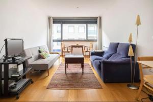 a living room with a blue couch and a table at Apartamento Centro de Baiona con Parking in Baiona