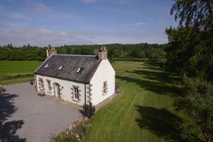 an aerial view of a white house in a field at Dunaincroy Farmhouse in Inverness