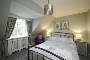 a bedroom with a bed and a window at Dunaincroy Farmhouse in Inverness