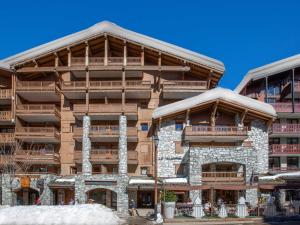 a large apartment building with snow around it at Studio de standing avec balcon au cœur du village, proche pistes et commodités - FR-1-694-85 in Val dʼIsère
