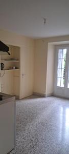 an empty room with a kitchen and a large window at Super Appartement in La Souterraine