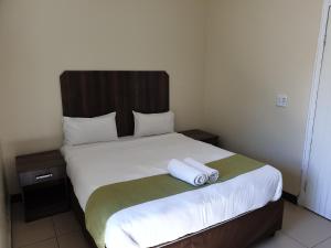 a bedroom with a bed with two towels on it at Cube Hotel in Durban