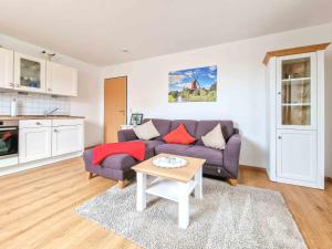 a living room with a purple couch and a table at Backbord in Greetsiel