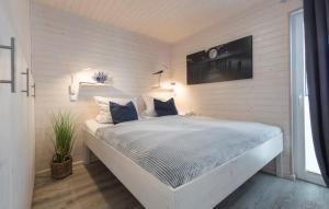 a white bedroom with a bed with blue pillows at Hausboot Isa-Bella in Burg