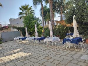 B&B LA COLIMENA في توري كوليمينا: مجموعة طاولات وكراسي مع مظلات