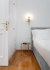 a bedroom with a bed and a table next to a door at The Aeolian in Athens