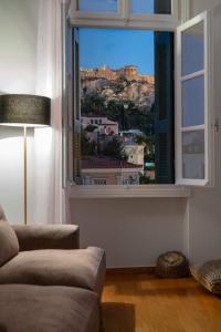 a living room with a couch and a large window at The Aeolian in Athens