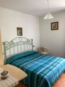 1 dormitorio con 1 cama grande con manta azul en La casetta al lavatoio, en Borgo a Mozzano