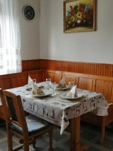 una mesa de comedor con platos y vasos. en Őrségi Lápréti Vendégház, en Szőce