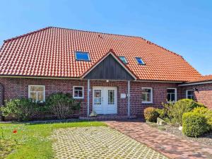 a red brick house with an orange roof at Backbord in Greetsiel