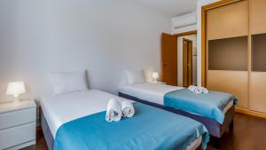 duas camas num quarto de hotel com toalhas em Luminous 2 BDR Apartment W/Pool by LovelyStay nos Olhos de Água