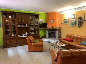 sala de estar con muebles de cuero y chimenea en La casetta al lavatoio, en Borgo a Mozzano