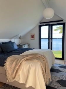 a bedroom with a bed and a large window at Stylish lake view house in Vadstena