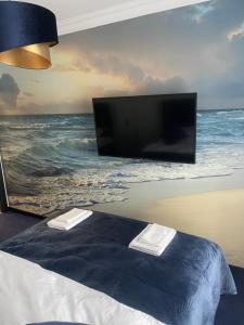 a bedroom with a flat screen tv and a bed at Baltic Apartment in Gdańsk