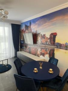 a dining room with a table with chairs and a city mural at Baltic Apartment in Gdańsk