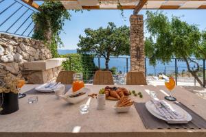 una mesa con comida y vistas al océano en Villa Mountain Lodge, en Omiš