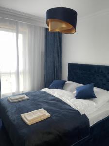 a bedroom with a blue bed with two towels on it at Baltic Apartment in Gdańsk