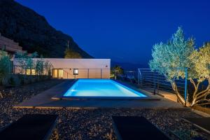 una piscina en el patio trasero de una casa por la noche en Villa Mountain Lodge, en Omiš