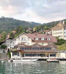 a large building on the water with boats in it at Dependance Stella del Lago by Hotel Restaurant Bellevue au Lac in Thun