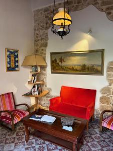 a living room with a red couch and a table at Locanda Sette Fate SPA e Solarium in Palermo