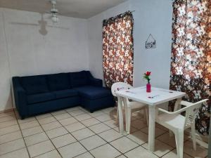 a living room with a blue couch and a table at Departamento 2 recamaras 1er pis in Kanasín