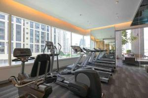 une salle de sport avec des rangées de machines à tapis roulant dans un bâtiment dans l'établissement 2BedRoom-BestLocationBangkok-Emquartier-Metro-PhromPhong, à Bangkok