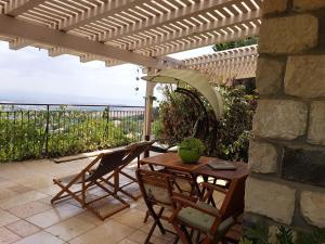a table and chairs on a patio with a view of the ocean at Neve Nof in Rosh Pinna