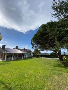 uma casa com um jardim verde com uma árvore em El Tejado de Santa Ana em Barrika