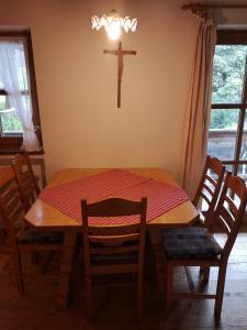 a dining room table with a cross on the wall at Ferienwohnung Niklas in Saulgrub