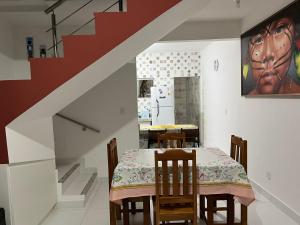 聖克魯斯－卡布拉利亞的住宿－Lindo Apê em Coroa Vermelha BA，一间带桌子和楼梯的用餐室