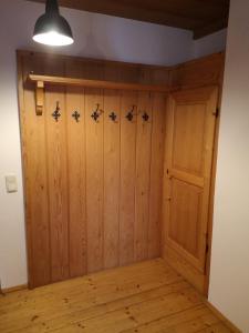 Zimmer mit einem Holzschrank und einer Tür in der Unterkunft Ferienwohnung Niklas in Saulgrub