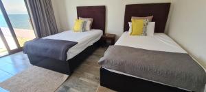 2 camas en una habitación con vistas al océano en Lake-front Delux home en Mangochi