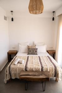 um quarto com uma cama grande e paredes brancas em Blue Waves Surf House em Agadir