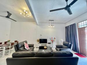uma sala de estar com um sofá e uma mesa em Cozy 10 Entire House 4 Bedroom At Alma Bukit Mertajam em Bukit Mertajam