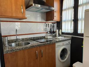 a kitchen with a sink and a washing machine at Apartamento Corredera in Córdoba