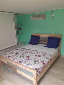 - une chambre avec un lit en bois aux murs bleus dans l'établissement Belle à la campagne, au Gosier