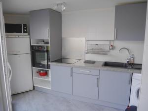 uma cozinha branca com armários e electrodomésticos brancos em Appartement Le Palais, 2 pièces, 3 personnes - FR-1-418-222 em Le Palais