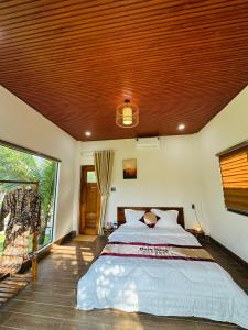 a bedroom with a large bed with a wooden ceiling at Bum King Resort Hồ Tràm in Xuyên Mộc +205 photos